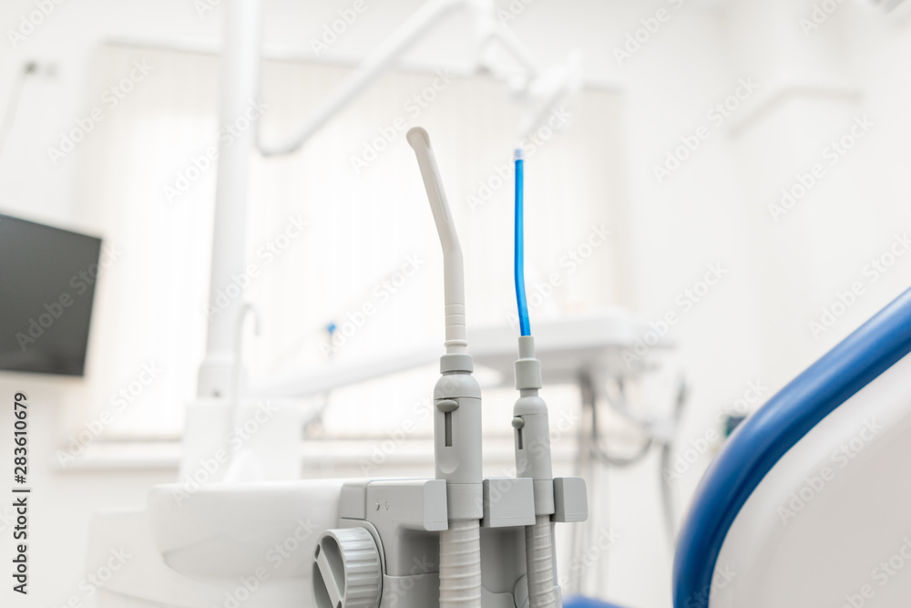 Close-up dentist saliva ejector. Dental work in clinic. Operation, tooth replacement. Medicine, health, stomatology concept. Office where dentist conducts inspection and concludes. Close-up dentist saliva ejector. Dental work in clinic. Operation, tooth replacement. Medicine, health, stomatology concept. Office where dentist conducts inspection and concludes.