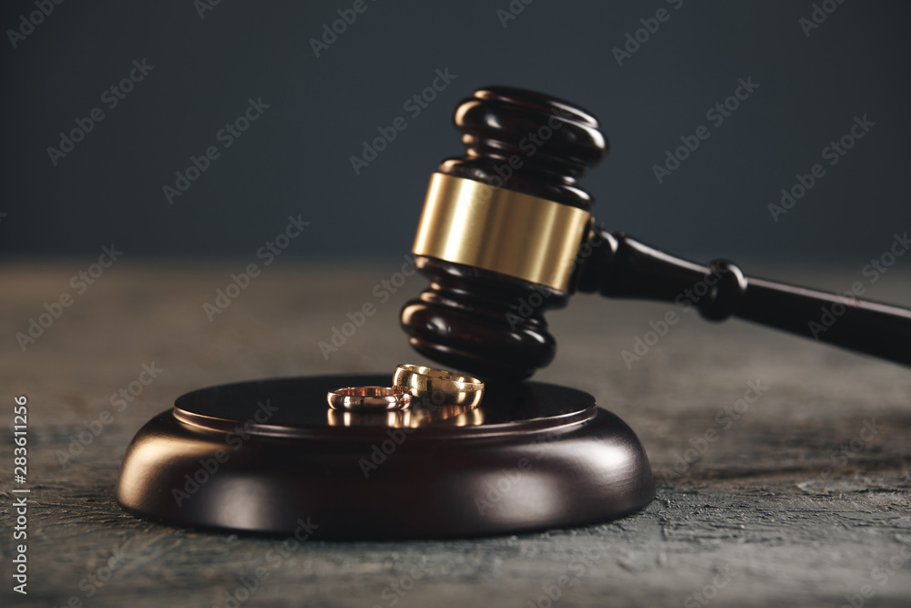 Wedding rings on the figure of a broken heart from a tree, hammer of a judge on a wooden background. Divorce proceedings Wedding rings on the figure of a broken heart from a tree, hammer of a judge on a wooden background. Divorce proceedings