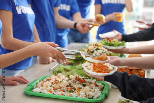 Volunteers serving food to poor people, closeup