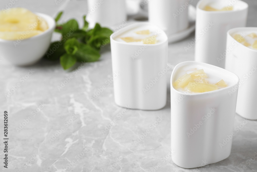 Cups of pineapple yogurt and ingredients on table, space for text. Multi cooker recipe Cups of pineapple yogurt and ingredients on table, space for text. Multi cooker recipe