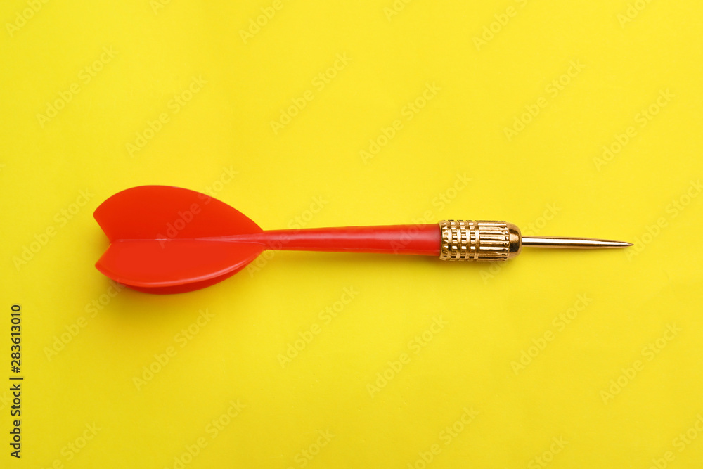 Red dart arrow on yellow background, top view Red dart arrow on yellow background, top view