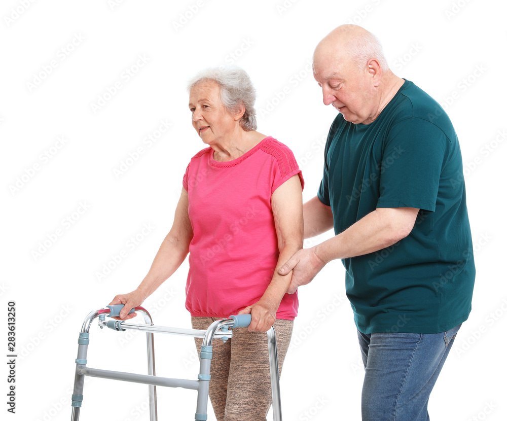 Elderly man helping his wife with walking frame on white background Elderly man helping his wife with walking frame on white background
