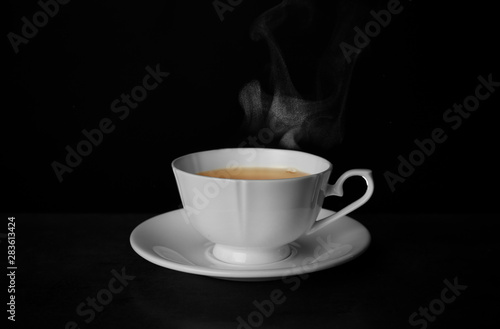 Ceramic cup of hot fresh tea on table against black background  space for text