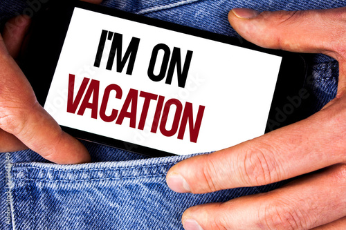 Word writing text I Am im On Vacation. Business concept for Break from stressful work pressure travel worldwide written Mobile phone holding by man the Jeans background. © Artur