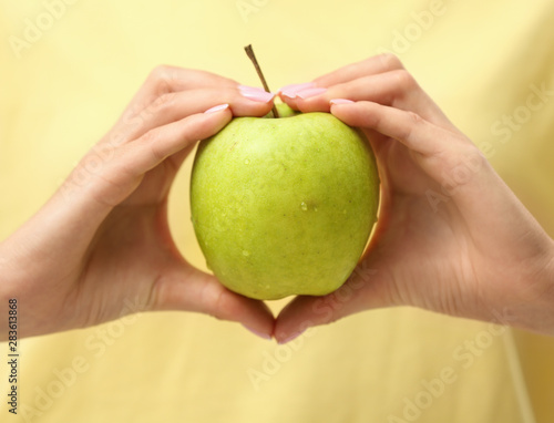 Woman holding fresh green apple indoors  closeup