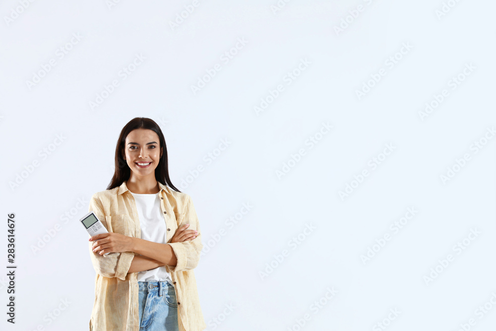 Young woman with air conditioner remote on white background Young woman with air conditioner remote on white background