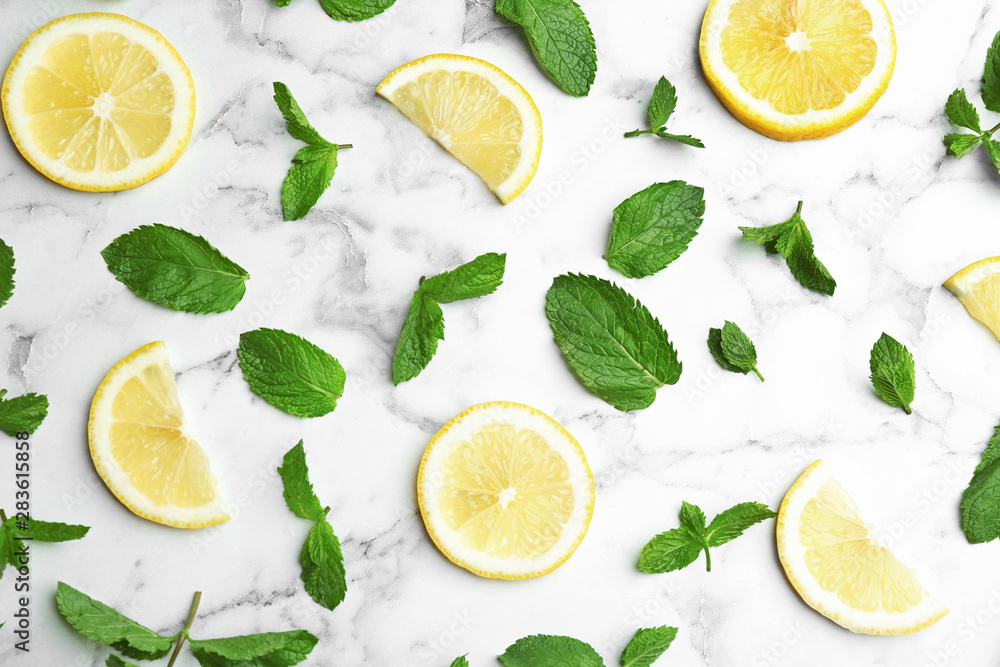 Fresh mint with sliced lemon on white marble background, flat lay Fresh mint with sliced lemon on white marble background, flat lay