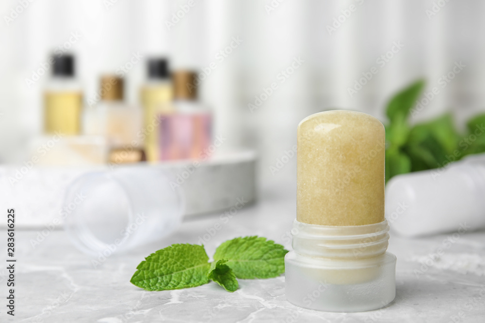 Natural crystal alum deodorant and mint on light grey marble table. Space for text Natural crystal alum deodorant and mint on light grey marble table. Space for text