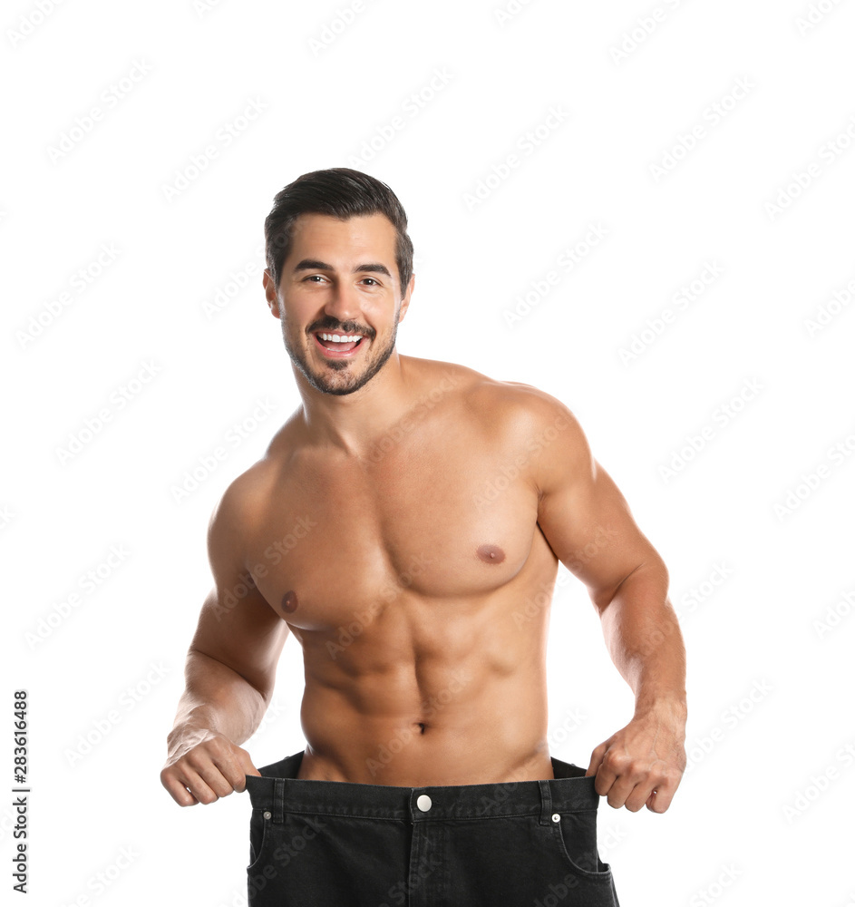 Young man with slim body in old big size jeans on white background