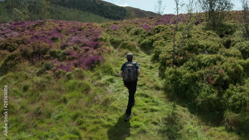 Aerial Flight view of photographer hiking on Cloughmore Stone area, Kilbroney Park,countryside Northern Ireland. Hiking And Tourism Concept