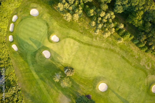 Aerial view of links golf course during summer showing green and bunkers at driving range photo