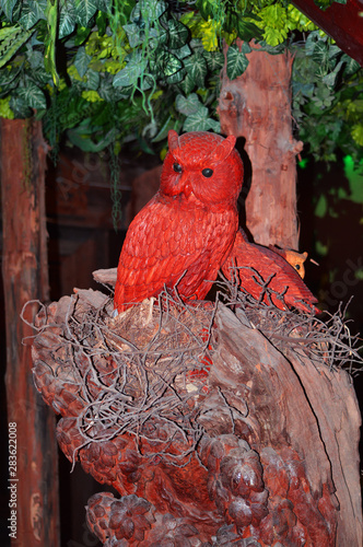 A red wooden owl sits on a timber,Thailand photo