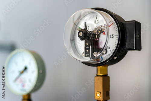 The equipment of the boiler-house, - valves, tubes, pressure gauges, thermometer. Close up of manometer, pipe, flow meter, water pumps and valves of heating system in a boiler room