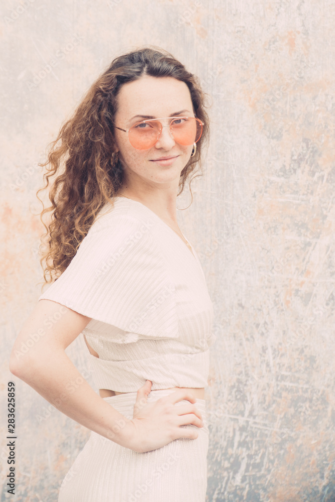 Millenial trendy Hipster teenager enjoys and relaxes during a walk in city center, she has orange lens sunglasses and white minimalistic dress, portraiture series, Millenial trendy Hipster teenager enjoys and relaxes during a walk in city center, she has orange lens sunglasses and white minimalistic dress, portraiture series,