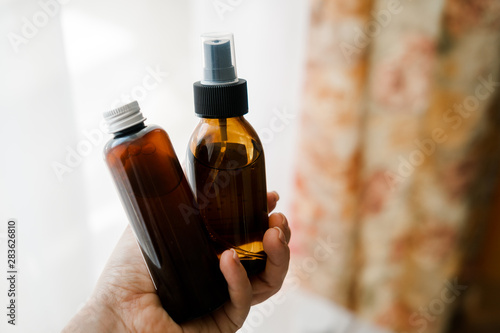 Two cosmetic bottles in woman's hands