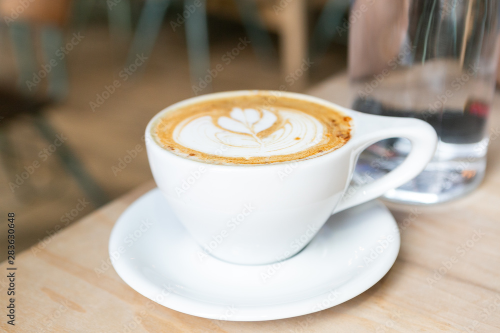 Cinnamon Latte in white mug on table at coffee shop Cinnamon Latte in white mug on table at coffee shop