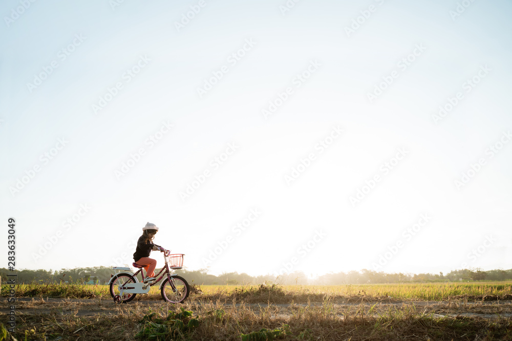 Obraz premium toddler enjoy riding her bicycle outdoor in beautiful day
