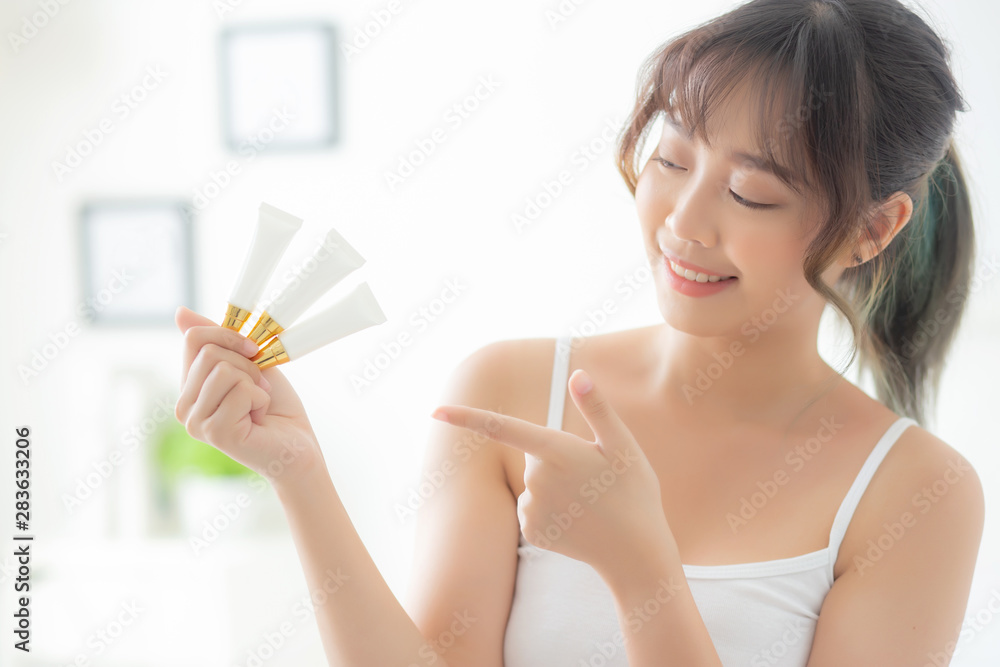 Beautiful portrait young asian woman holding and pointing presenting cream or lotion product, beauty asia girl show cosmetic makeup and moisturizing for skin care, healthy and wellness concept. Beautiful portrait young asian woman holding and pointing presenting cream or lotion product, beauty asia girl show cosmetic makeup and moisturizing for skin care, healthy and wellness concept.