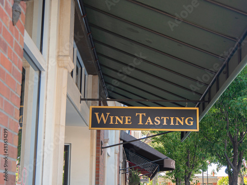Wine Tasting Sign Hanging In Front Of Downtown Shops