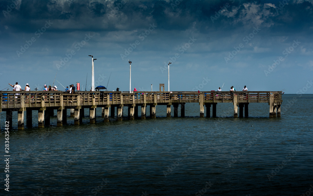 Fishing Pier With Storm Clouds Rolling In on People fishing