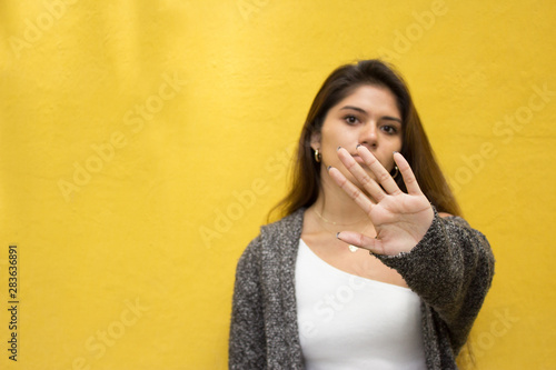 Teenage girl with her hand in front of her face