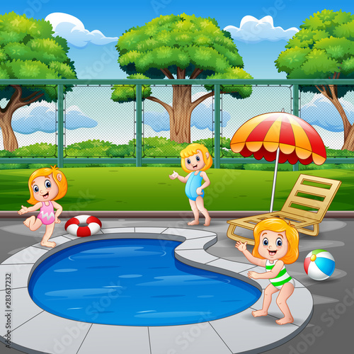 Happy little girls playing in the swimming pool