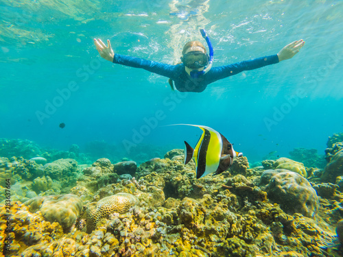 Happy woman in snorkeling mask dive underwater with tropical fishes in coral reef sea pool. Travel lifestyle, water sport outdoor adventure, swimming lessons on summer beach holiday © galitskaya