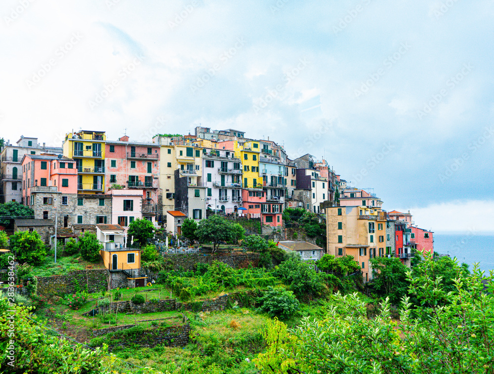 Fototapeta premium View of the houses and nature of Corniglia, one of the Cinque Terre villages in Liguria, Italy. Mediterranean sea and green mountains.