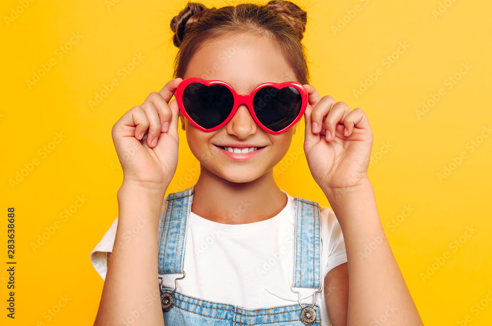 Stylish teenager in sunglasses, happy girl posing on yellow background. Stylish teenager in sunglasses, happy girl posing on yellow background.