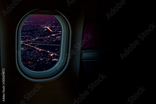 Night cityscapes view from airplane window in the sky with dark copy space for text