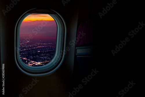 Night cityscapes view from airplane window in the sky with dark copy space for text