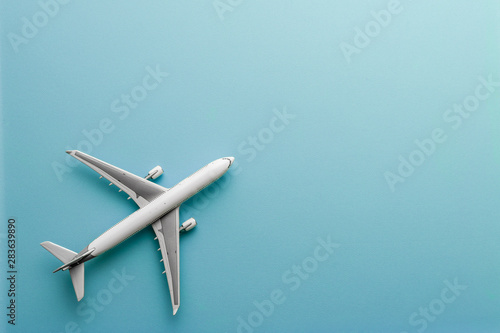 White model airplane on pastel color background with copy space flat lay design