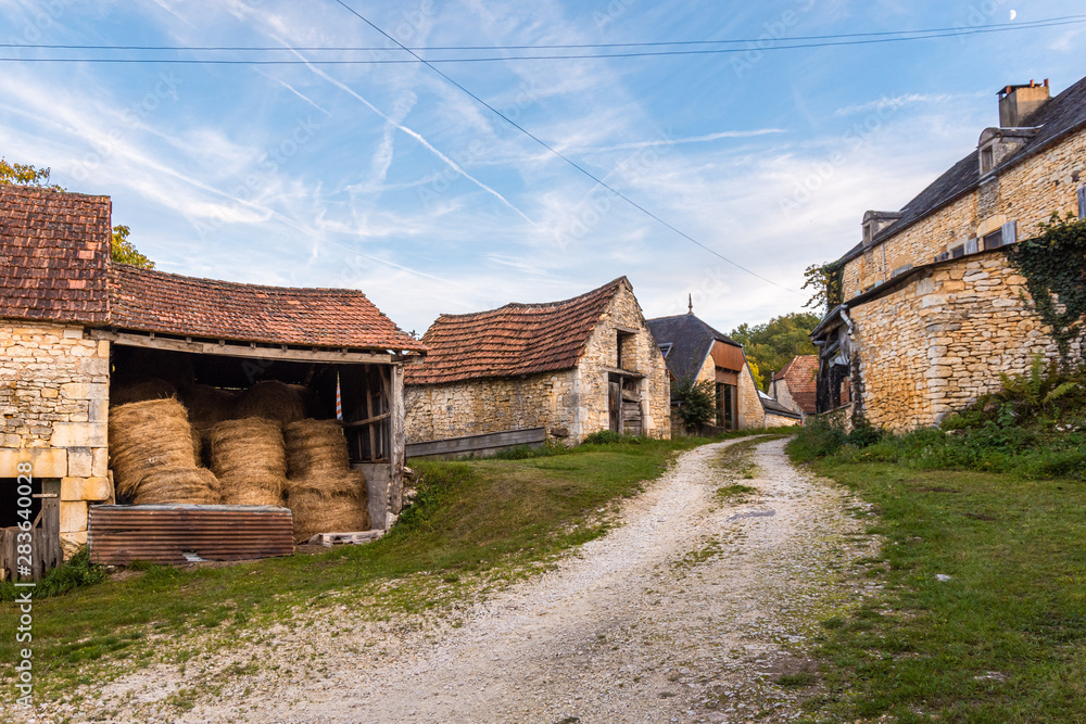 Gravel road passing through old French farmhouses Gravel road passing through old French farmhouses