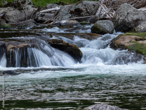 fresh clean water running over rocks creating small waterfalls © Taya