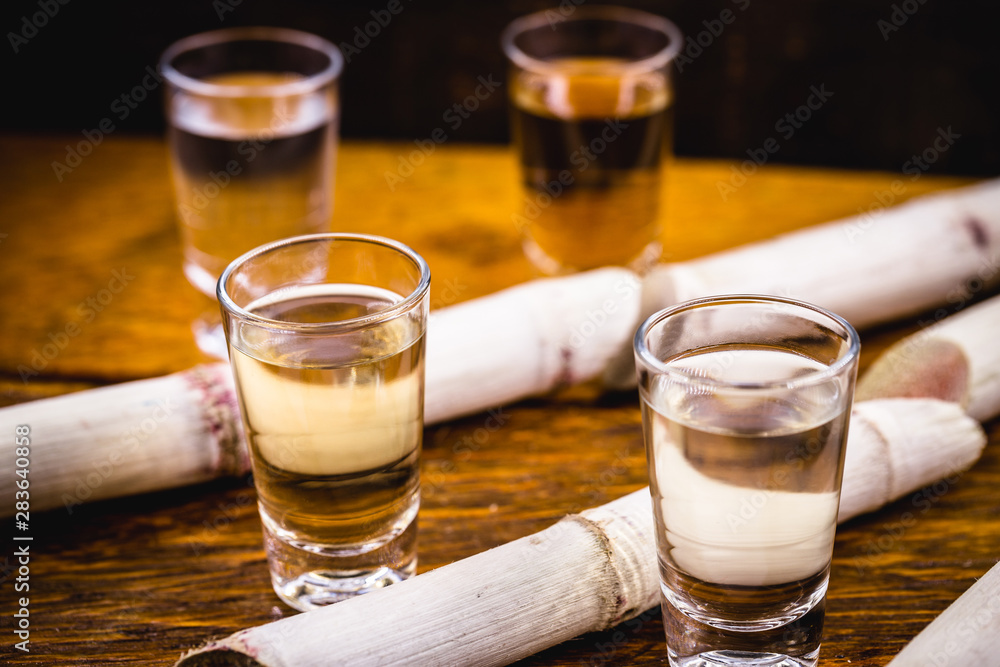 Two glasses of Brazilian gold and white cachaça isolated on rustic wooden background. Typical alcoholic drink from Brazil. Two glasses of Brazilian gold and white cachaça isolated on rustic wooden background. Typical alcoholic drink from Brazil.