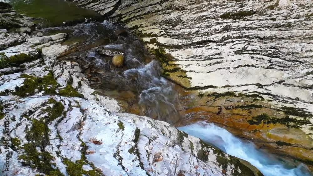 Mountain river at summer sunny day in ravine, water among stones