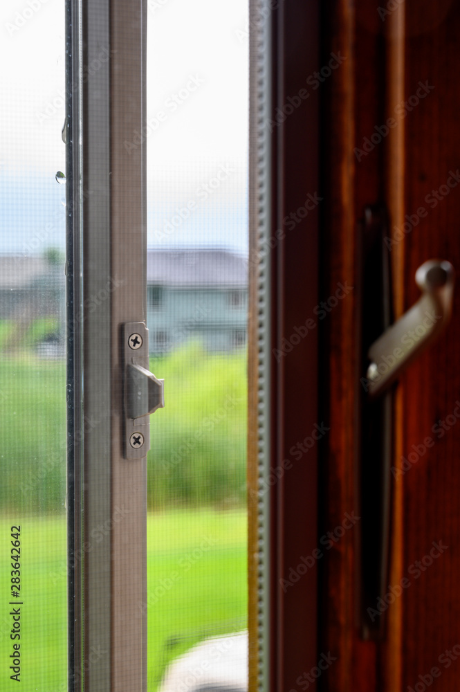 Open window with latch on dark wood frame Open window with latch on dark wood frame