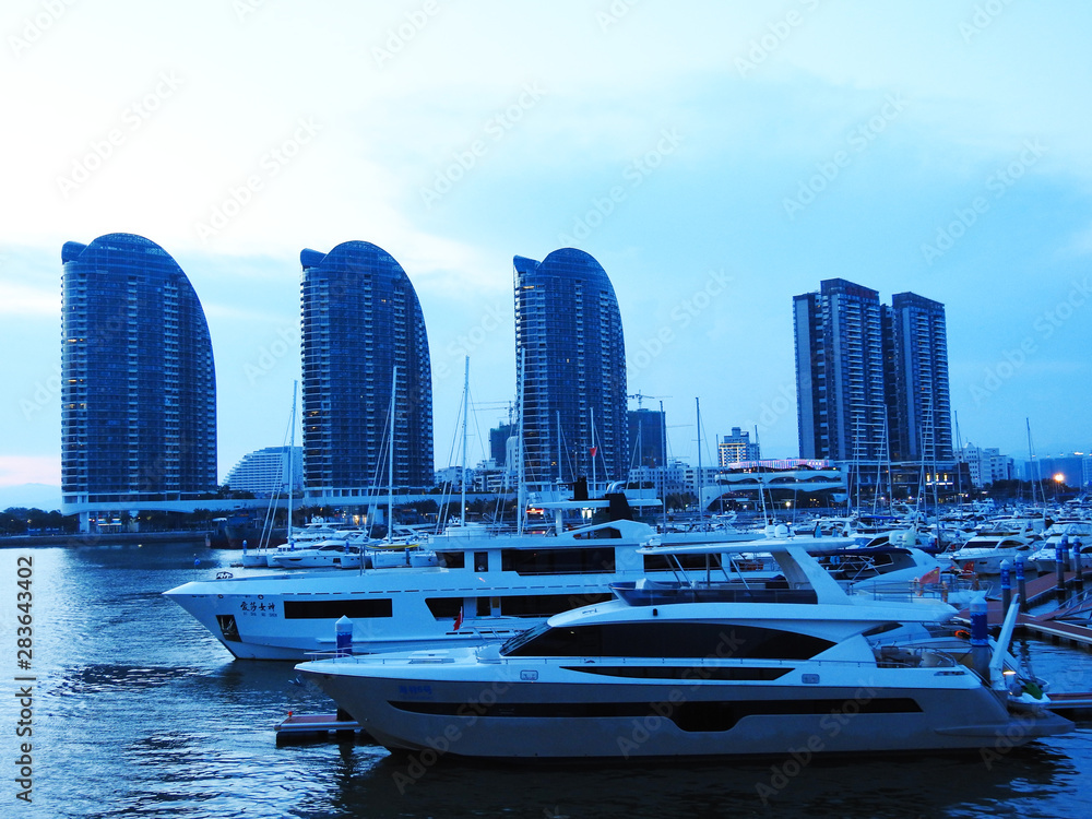 Obraz premium Hainan, Sanya, China-July 20, 2019. Evening pier. Boats. Yachts. Water infrastructure.