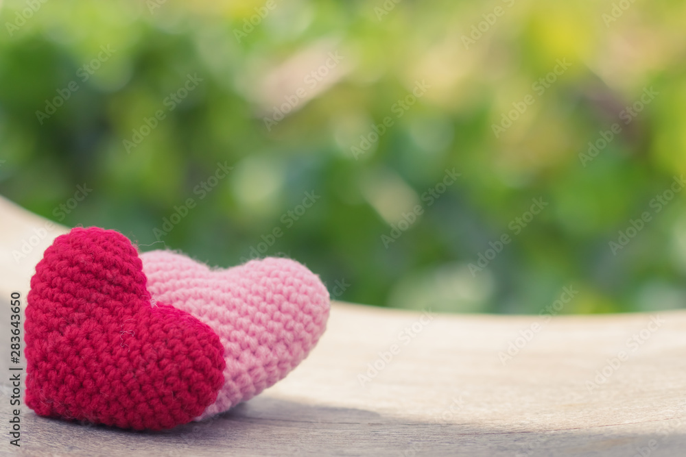 Fototapeta premium Red and pink hearts on wooden swing with beautiful blurred background