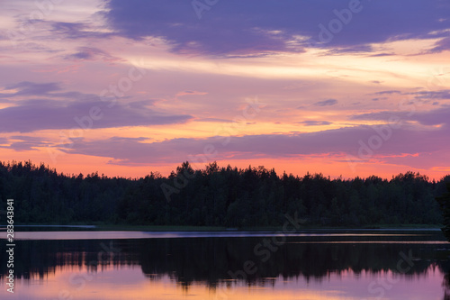 dramatic sunset over a forest lake © Maslov Dmitry