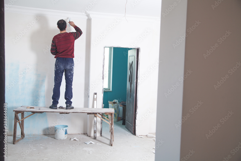 Man painting wall with white color. Renovation