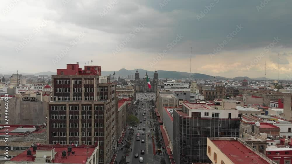 Aerial view of Zocalo in Mexico City, the Monumental Flag and the Cathedral. Drone flying forward and descending Aerial view of Zocalo in Mexico City, the Monumental Flag and the Cathedral. Drone flying forward and descending