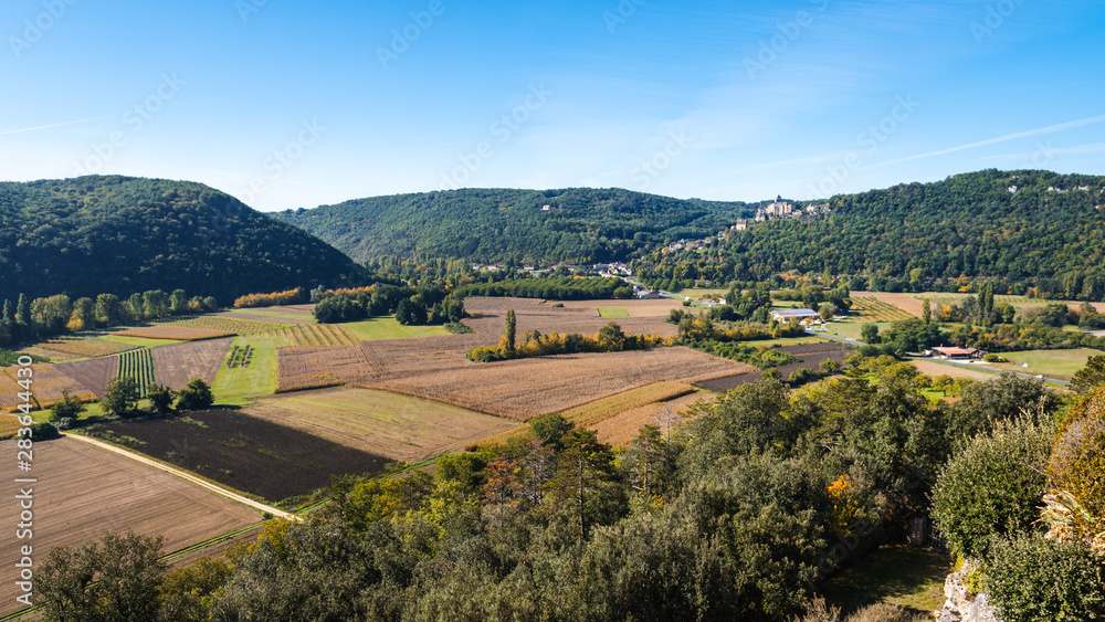 View over farms in the Dordogne valley towards the medieval chateau of Castelnaud-la-Chapelle