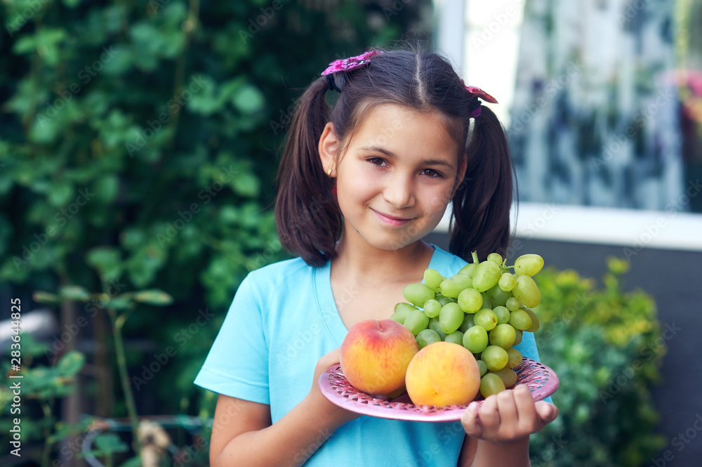 Portrait of a beautiful girl with peaches . The child holds fresh ripe fruit in his hands Portrait of a beautiful girl with peaches . The child holds fresh ripe fruit in his hands