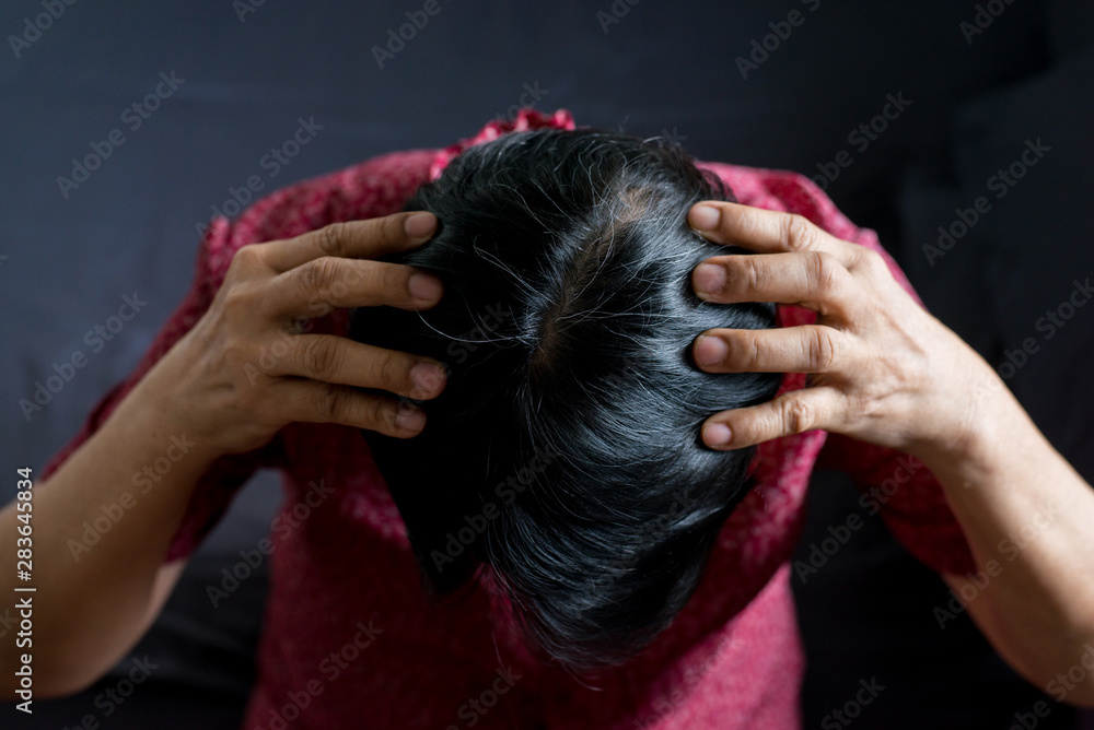 Naklejka premium Woman showing black gray hair roots on her head,Close up,Top view