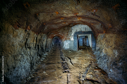 Dark dirty abandoned uranium mine with rusty remnants of railway © Mulderphoto