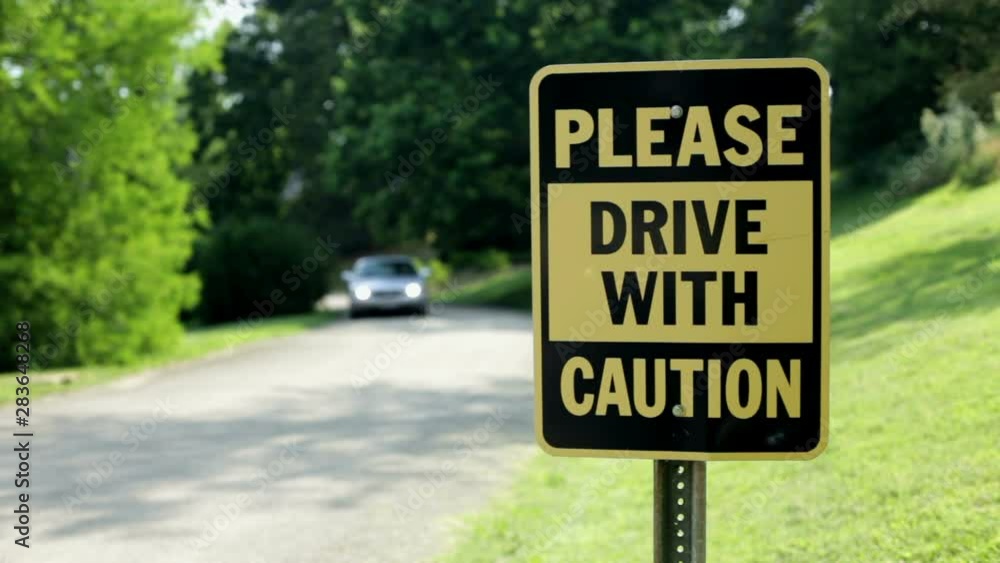 Car driving towards a sign that reads 'Drive with Caution'.
Car driving towards a sign that reads 'Drive with Caution'.