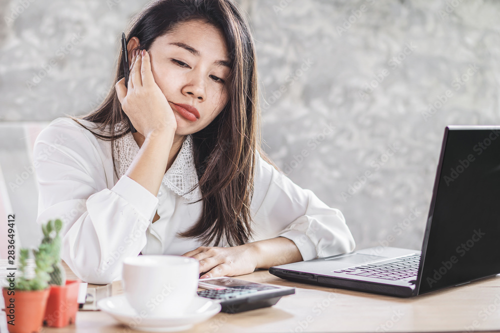 unmotivated Asian woman worker lazy and bored to work wasting time at office desk unmotivated Asian woman worker lazy and bored to work wasting time at office desk