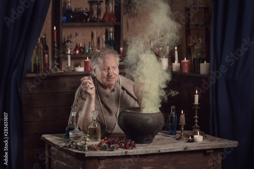 elderly alchemist monk brews magic potion