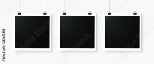 Three empty photo frames hanging on a bulldog clip. Digital snapshot image. 
